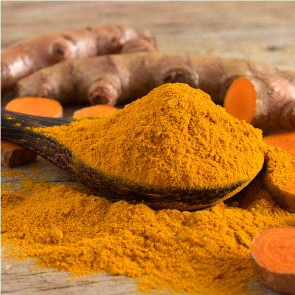 Spoonful of Bright yellow-orange Curcumin powder
