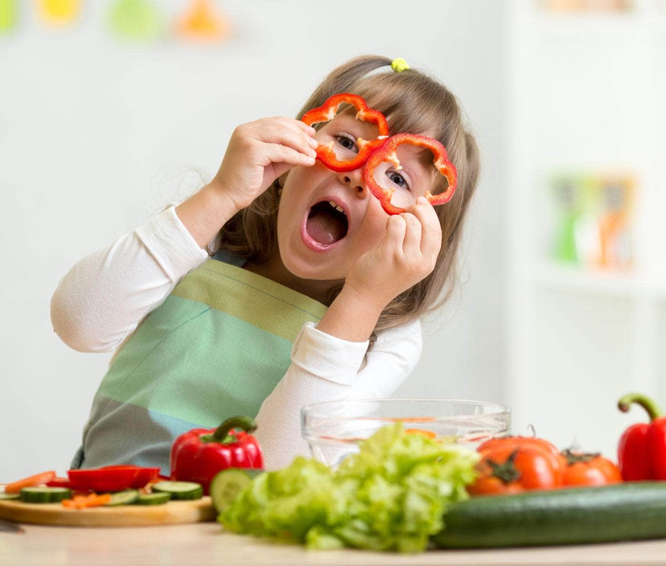 child playing with vegetables