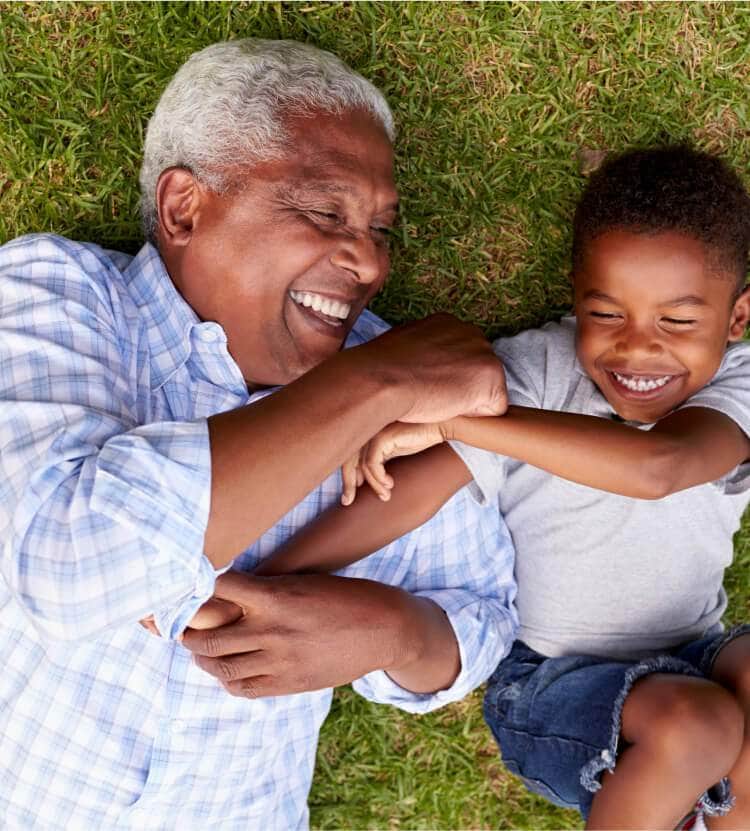 An old man with his grandkid laying in park