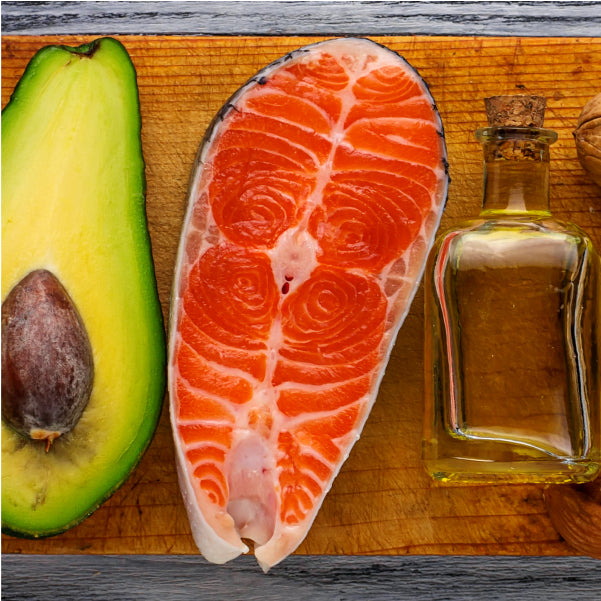 Avocado, Salmon and olive oil on a chopping board